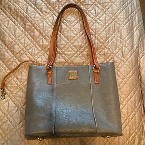 Taupe colored Dooney and Bourke 10 inches high 12 inches wide.